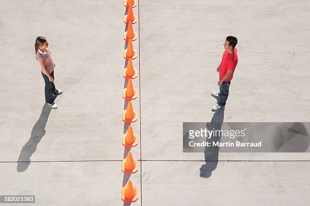 man and woman on either side of row of traffic cones looking back - men double stock pictures, royalty-free photos & images