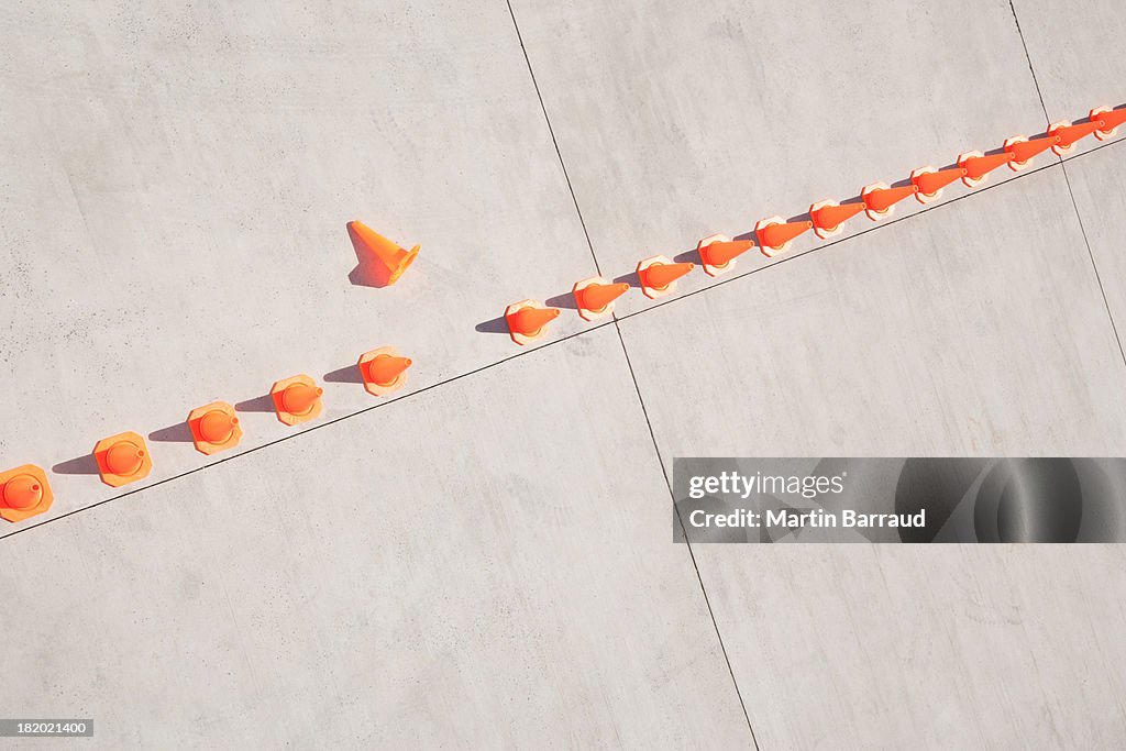Row of traffic cones with one on side