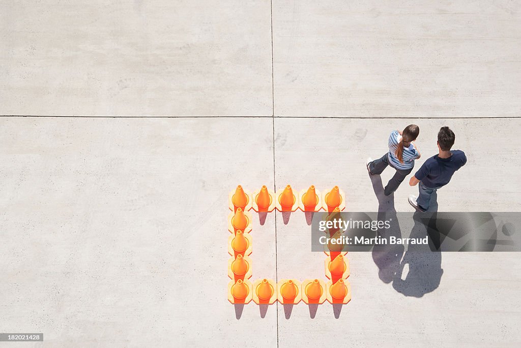 Woman and man outside box of traffic cones