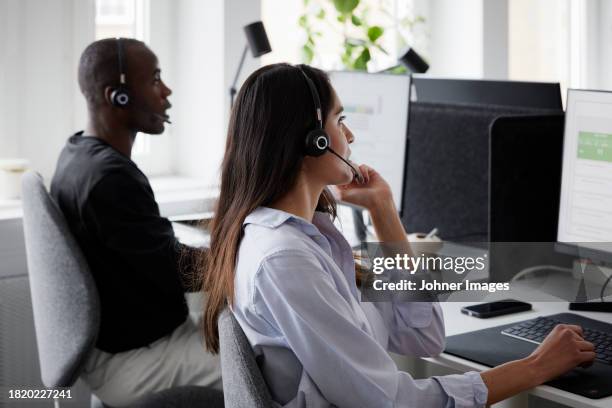 woman wearing headset using desktop pc in office - callcenter bildbanksfoton och bilder