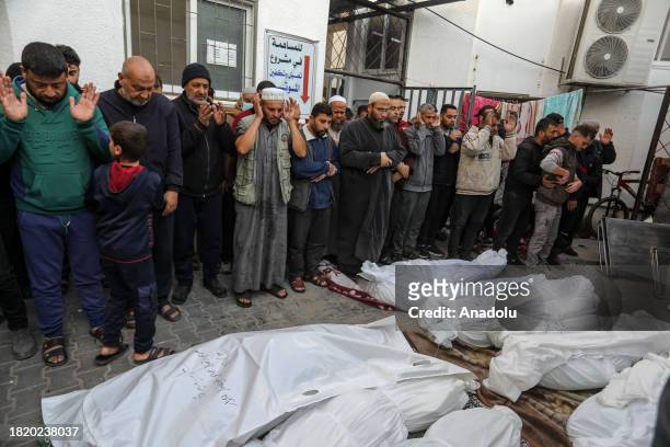 People perform funeral prayer near dead bodies, killed in the Israeli attacks, at El-Najar Hospital prior to burial in Rafah, Gaza on December 04,...