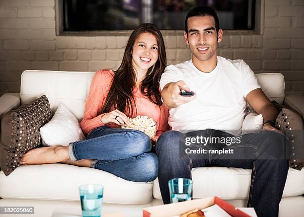 young adults watching tv - watching tv couple night stock pictures, royalty-free photos & images