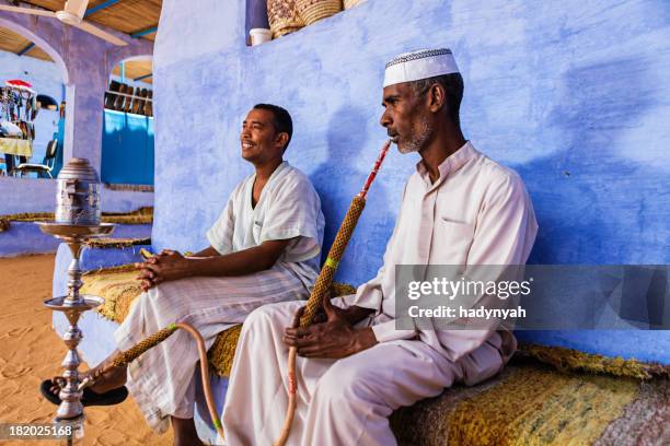 nubian men smoking waterpipe in southern egypt - aswan stockfoto's en -beelden