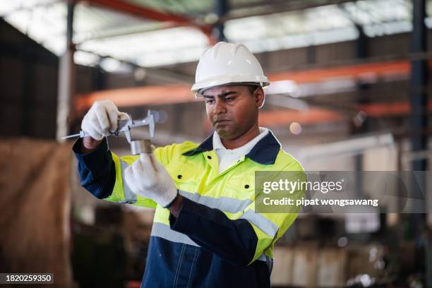 engineer is using a vernier caliper to measure the thickness of a factory spare part. - vernier caliper stock-fotos und bilder