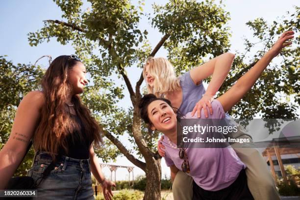 young female friends having fun together outdoors - dreiviertel vorderansicht stock-fotos und bilder