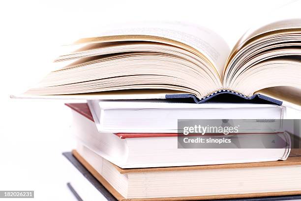 stack of books with the book on top cracked open  - textbook stack stock pictures, royalty-free photos & images