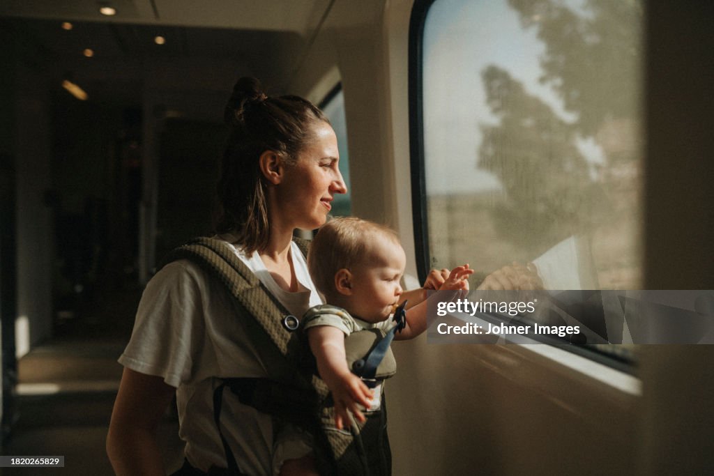 Mother with baby looking through train window
