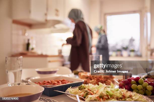 women preparing eid al-fitr at home - arab-family-iftar stock pictures, royalty-free photos & images