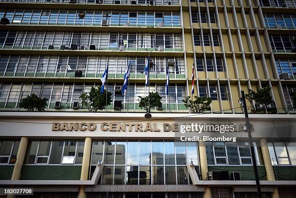 Flags fly at the Central Bank of Honduras in Tegucigalpa, Honduras, on on Wednesday, Sept. 4, 2013. Economic growth in Honduras is forecast to slow...