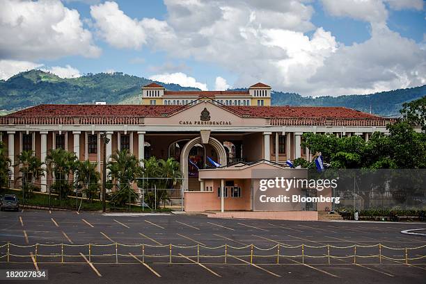 Flags wave in front of the Presidential Palace in Tegucigalpa, Honduras, on Saturday, Sept. 7, 2013. Economic growth in Honduras is forecast to slow...