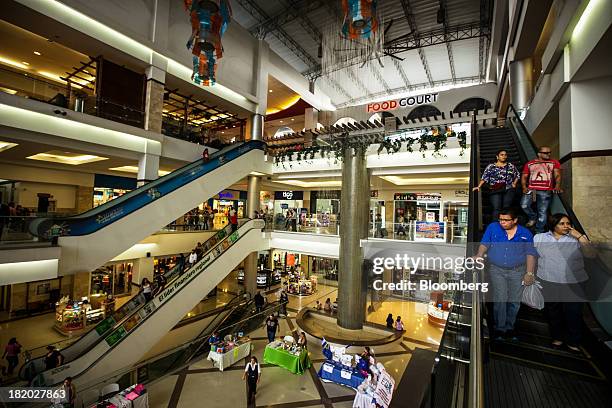 Shoppers ride an escalator in a mall in the Los Proceres section of Tegucigalpa, Honduras, on Saturday, Sept. 7, 2013. Economic growth in Honduras is...
