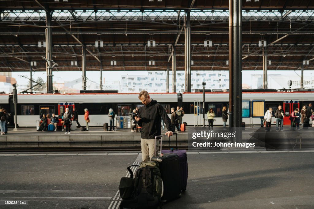 Man with large suitcases standing on platform