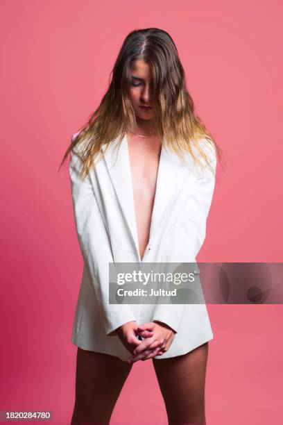 young woman in white blazer on colored background, with hair over her face. - no pants day photos et images de collection