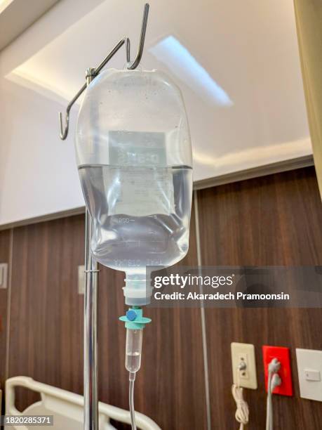 close up of a drip stand dispensing saline solution - saline drip stock pictures, royalty-free photos & images