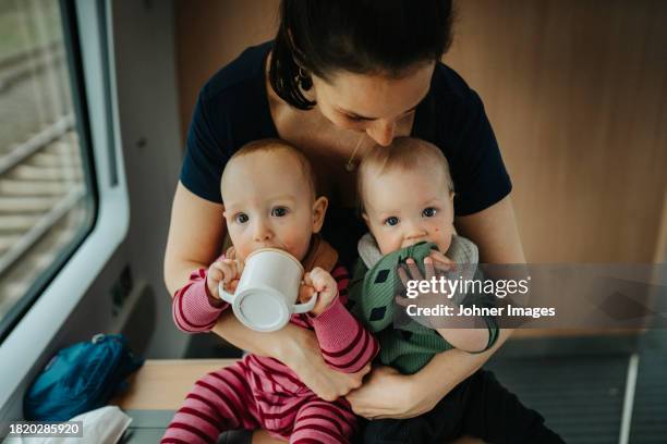 mother embracing twin babies at home - gêmeos nascimento múltiplo - fotografias e filmes do acervo