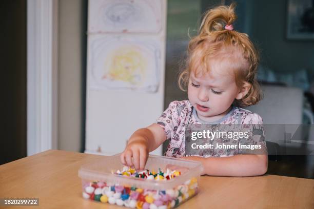 girl with beads in box on table at home - white bead stock pictures, royalty-free photos & images