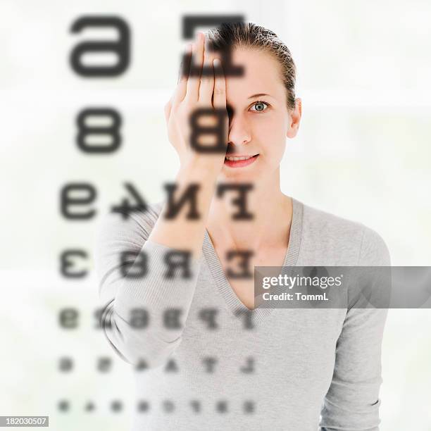 woman doing eye exam at optometrist - eye test chart stock pictures, royalty-free photos & images