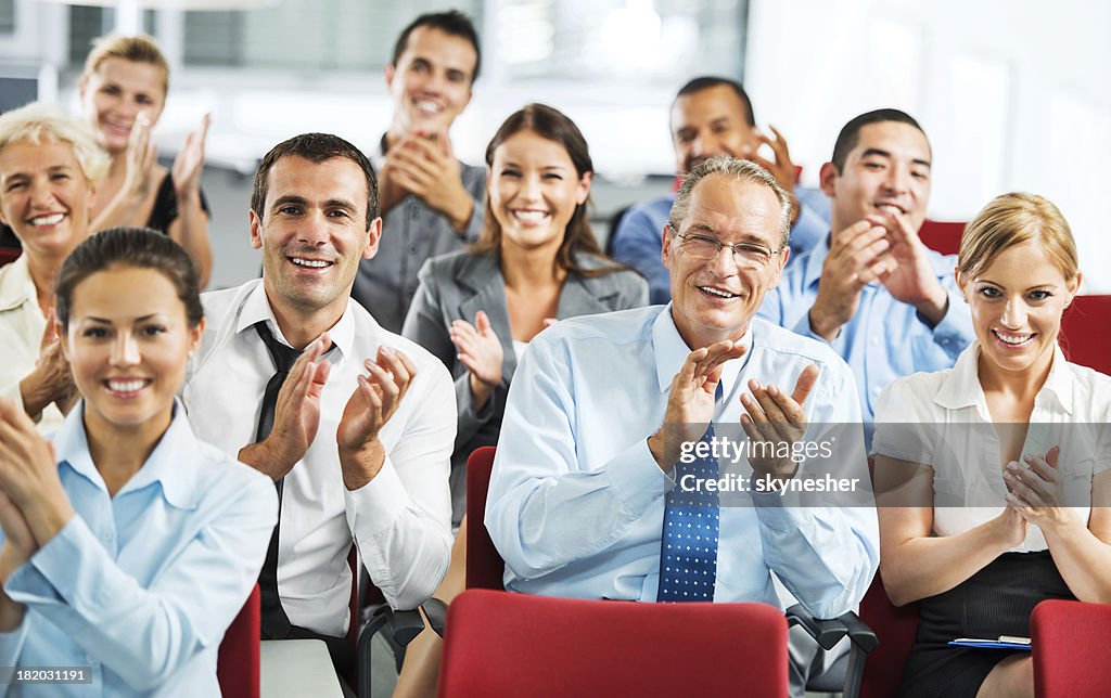 Businesspeople applauding during seminar.