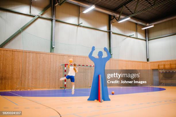 female handball player aiming with ball in sports court - västra götaland county stock pictures, royalty-free photos & images