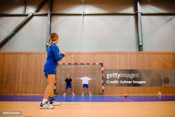 side view of female handball player preparing to throw ball in sports court - västra götaland county stock pictures, royalty-free photos & images