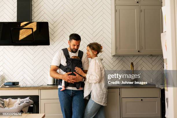father and mother with son in kitchen at home - vaterschaft stock-fotos und bilder