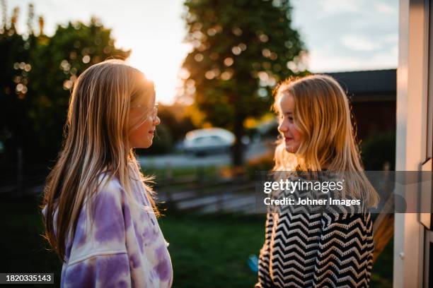 smiling female friends with blond hair looking at each other - västra götaland county stock pictures, royalty-free photos & images
