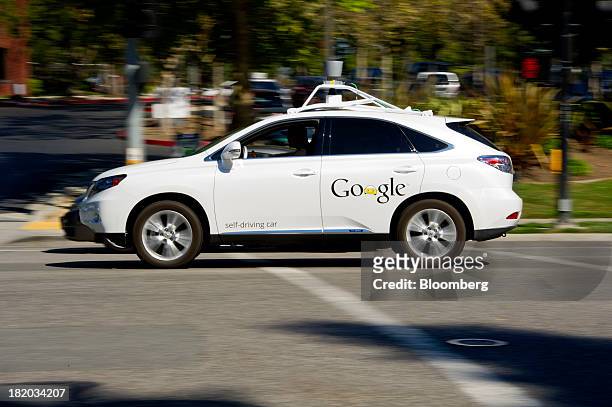 Man drives a Google Inc. Self-driving car in front of the company's headquarters in Mountain View, California, U.S., on Friday, Sept. 27, 2013....