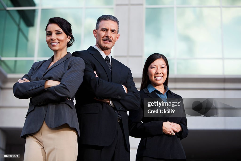 Team of businesspeople standing outside office building