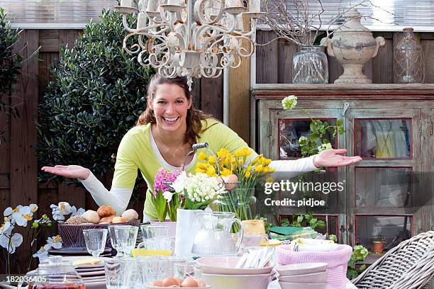 happy woman standing at easter breakfast picnic table - easter breakfast stock pictures, royalty-free photos & images