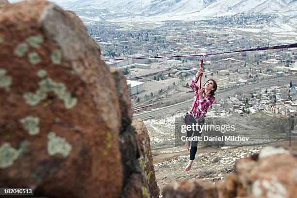 girl hanging off of a high line, over a small town - glen haven co stock pictures, royalty-free photos & images