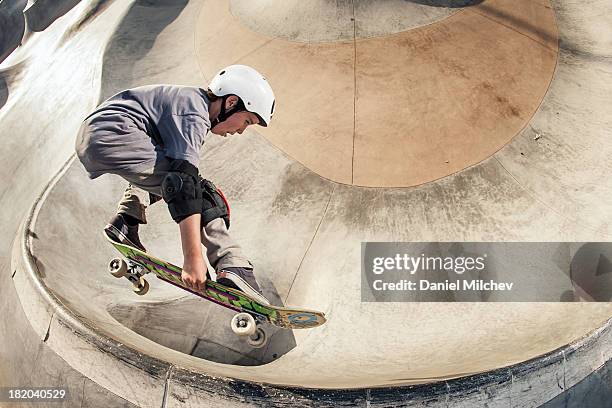 young skateboarder jumping over an opening. - boy skatepark stock-fotos und bilder