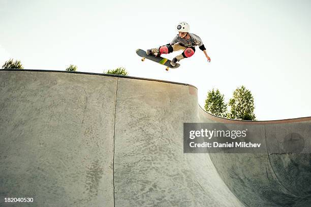 young skateboarder jumping at a skate park. - skateboarding stock pictures, royalty-free photos & images
