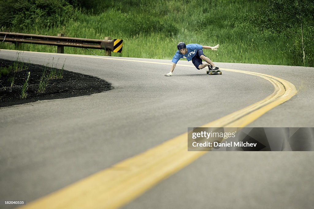 Skateboarder taking a sharp turn with high speed.