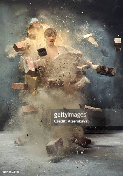 l'uomo attraverso rotto muro - distruzione foto e immagini stock