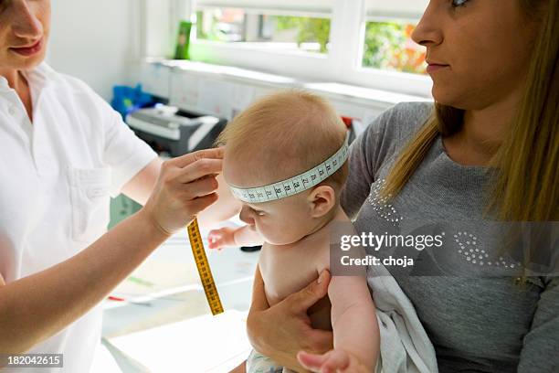 young mother with her child at pediatrician...routine check - baby m stock pictures, royalty-free photos & images