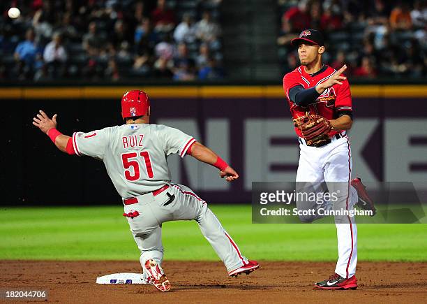 Andrelton Simmons of the Atlanta Braves turns a double play against Carlos Ruiz of the Philadelphia Phillies at Turner Field on September 27, 2013 in...