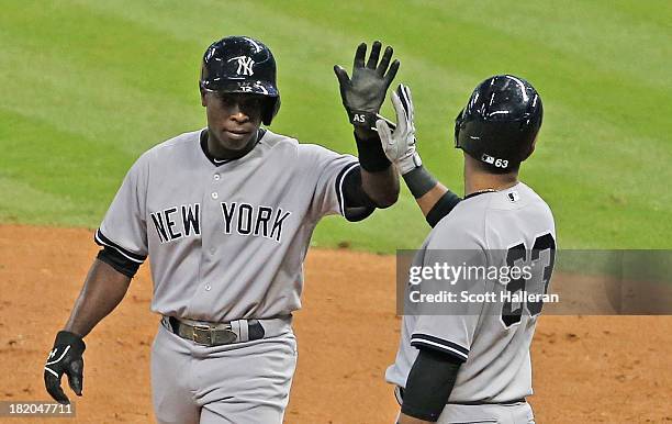 Alfonso Soriano of the New York Yankees is greeted at home plate by Zoilo Almonte after Soriano scored a run in the fourth inning against the Houston...