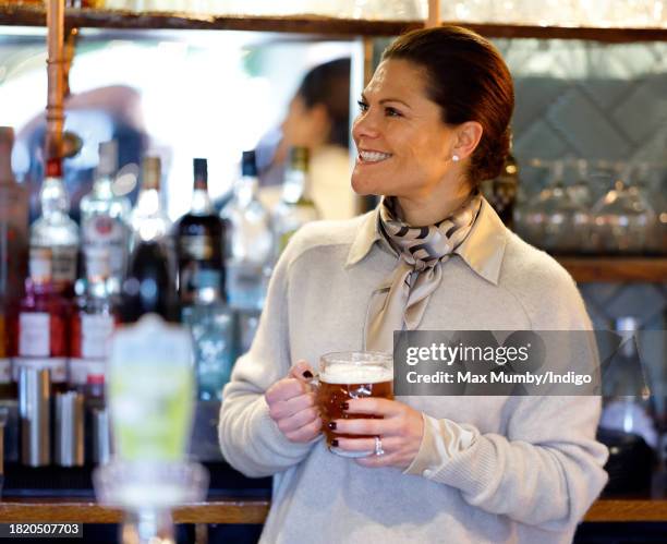 Crown Princess Victoria of Sweden holds a pint of beer she pulled as she visits the Three Blackbirds Pub, Woodditton to meet a pub owner to discuss...