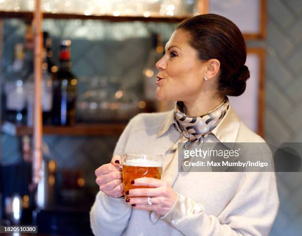 Crown Princess Victoria of Sweden holds a pint of beer she pulled as she visits the Three Blackbirds Pub, Woodditton to meet a pub owner to discuss...