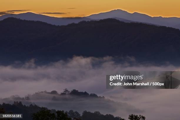 scenic view of silhouette of mountains against sky at sunset - glenn marshal stock pictures, royalty-free photos & images