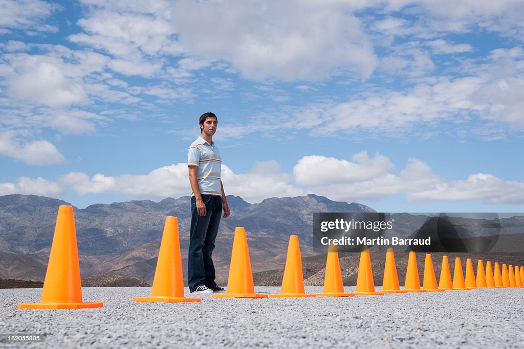 Homem de pé perto de cones de trânsito ao ar livre