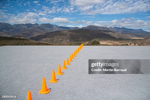 traffic cones in line outdoors ground level view - conformity stock pictures, royalty-free photos & images