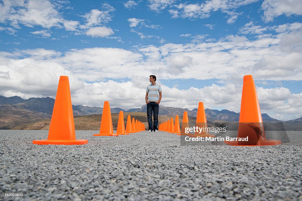 Man standing in-between two rows of safety cones