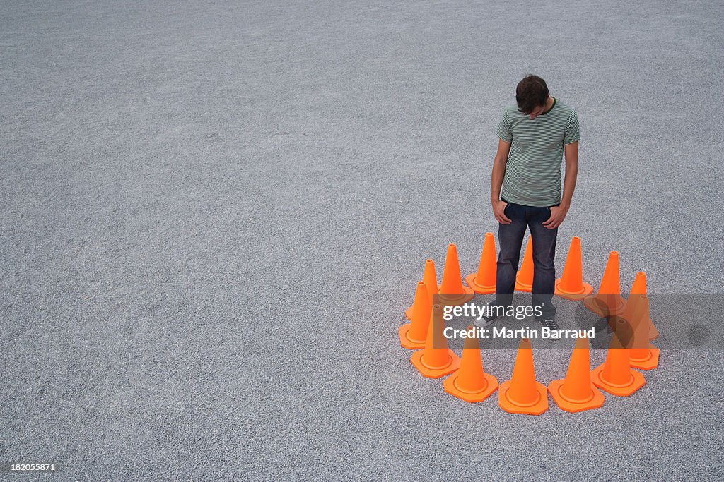 Man encircled by safety cones