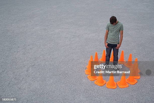 man encircled by safety cones - trap stock pictures, royalty-free photos & images