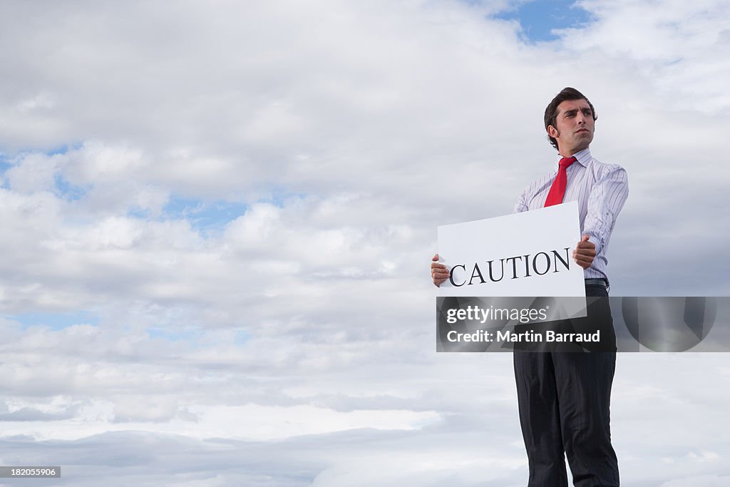 Man holding a caution placard