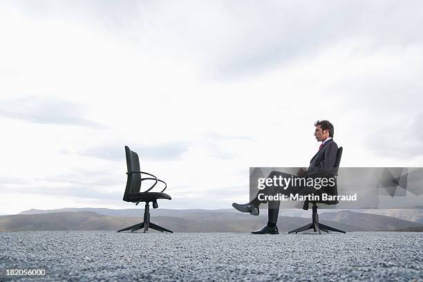 mann sitzt im büro stuhl im freien - office chair stock-fotos und bilder