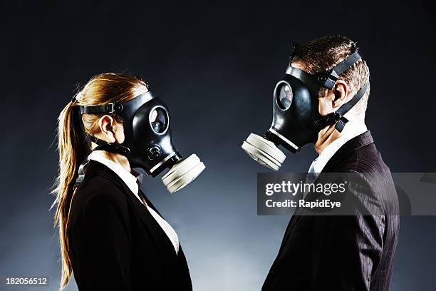 couple in gas masks face off confronting each other - bad breath stock pictures, royalty-free photos & images