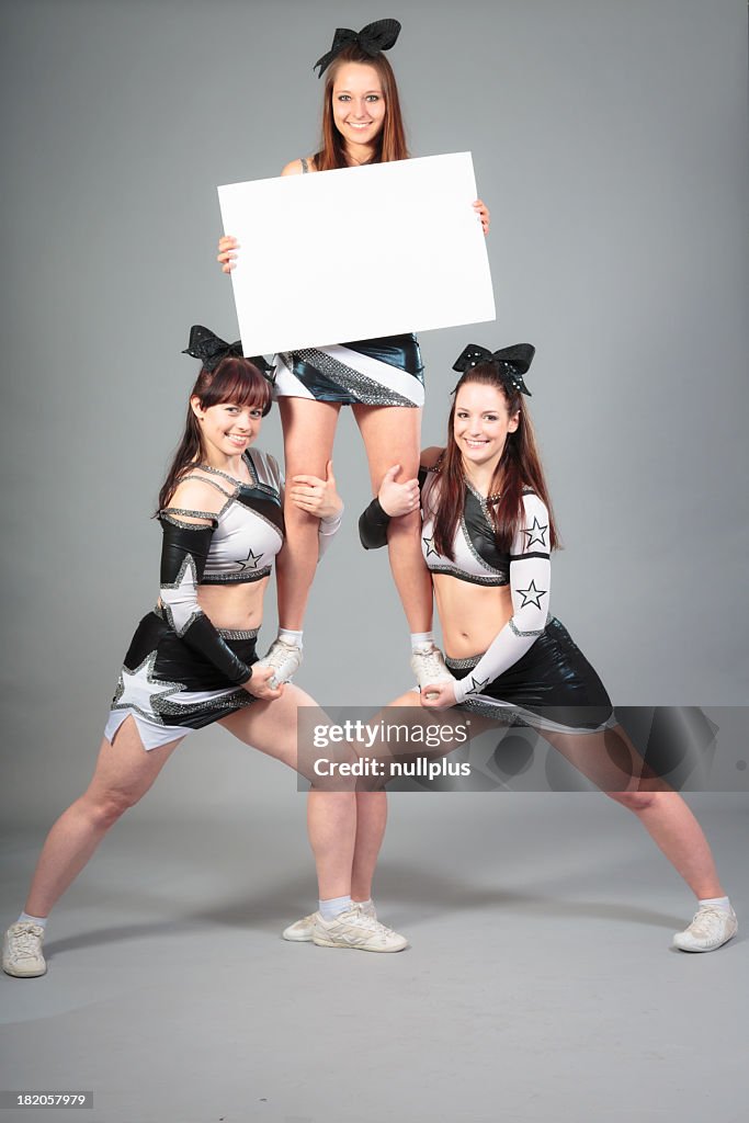 Cheerleader team performing a thigh stand
