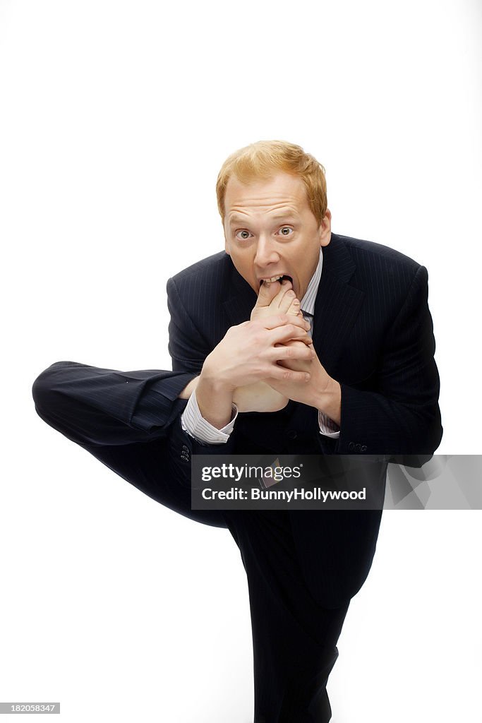 Funny businessman foot in mouth on White